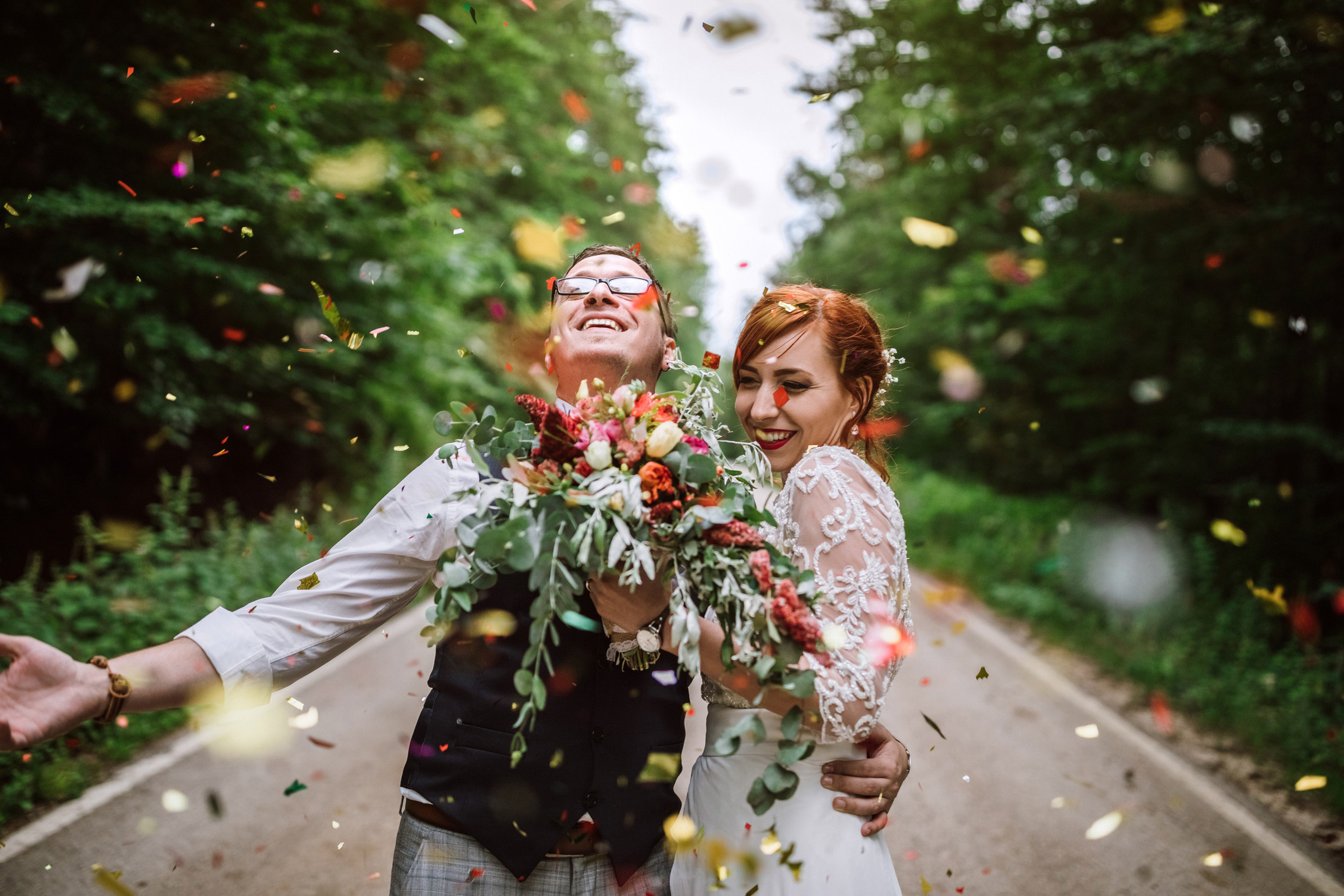 couple happy throwing wedding pedals up